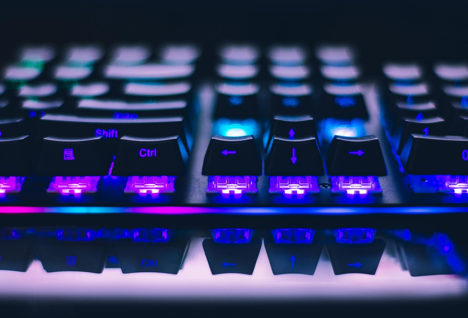 pexels-photo-2115257-2115257 A detailed close-up of illuminated mechanical keyboard keys with focus on blue and purple lights.